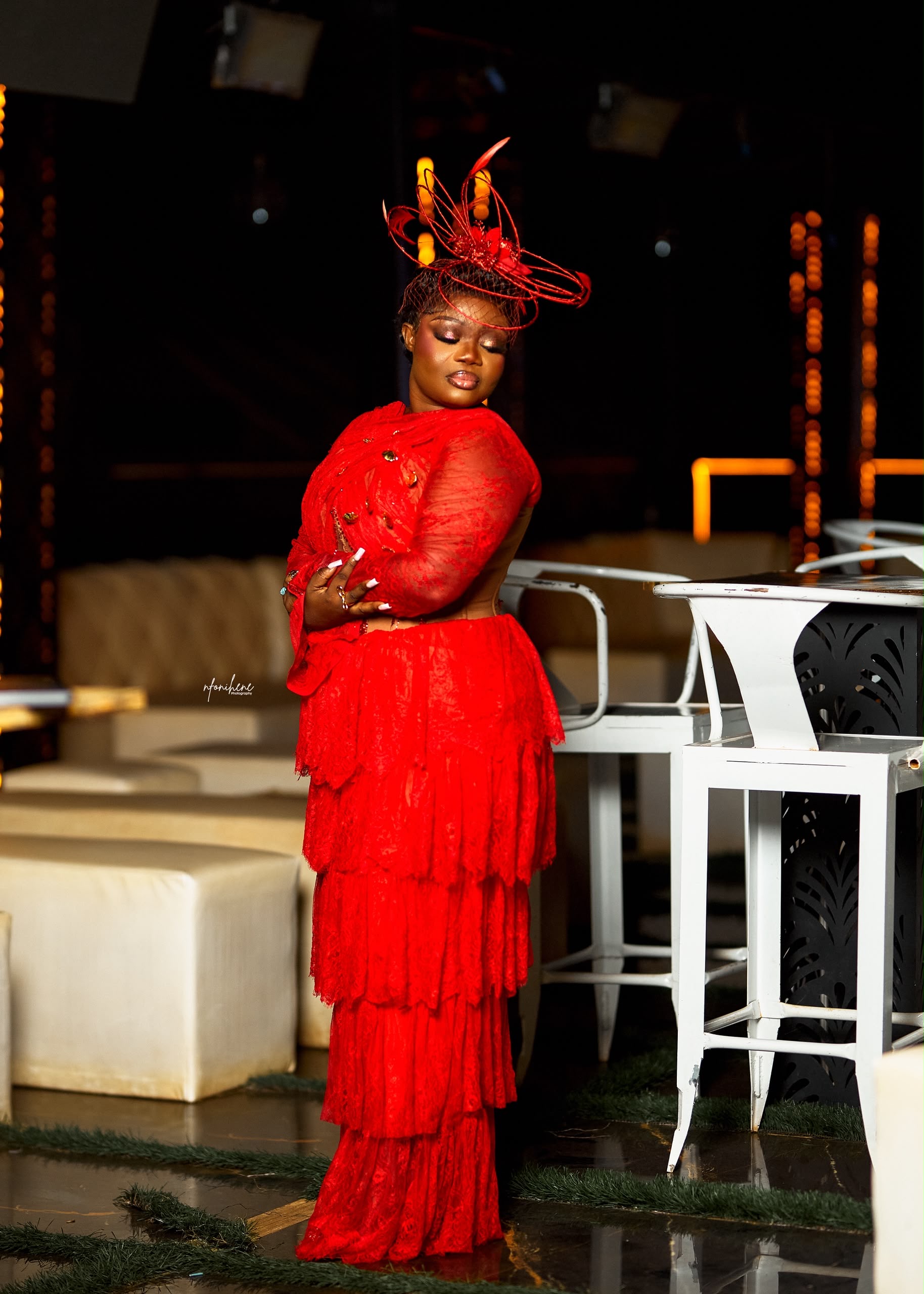 Tiered lace evening gown with feathered headpiece
